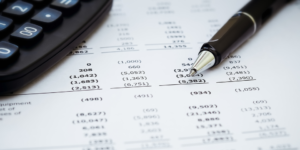Pen and calculator on top of financial report