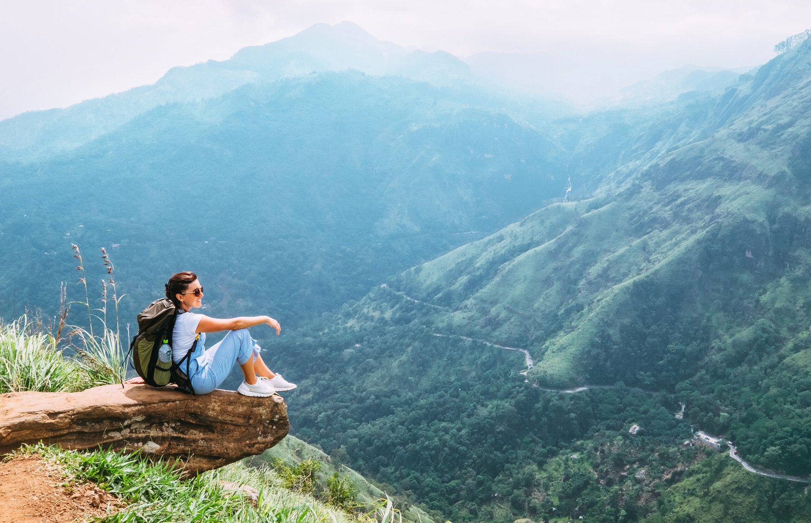 dreamstime_l_119582553 Woman sitting on top of a mountain